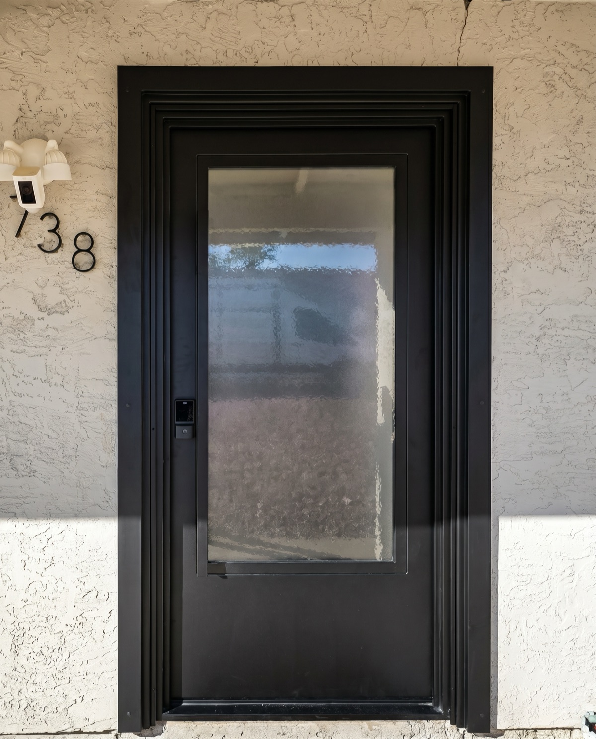 Black-frame residential entry door with privacy glass by Mad Touch Glass
