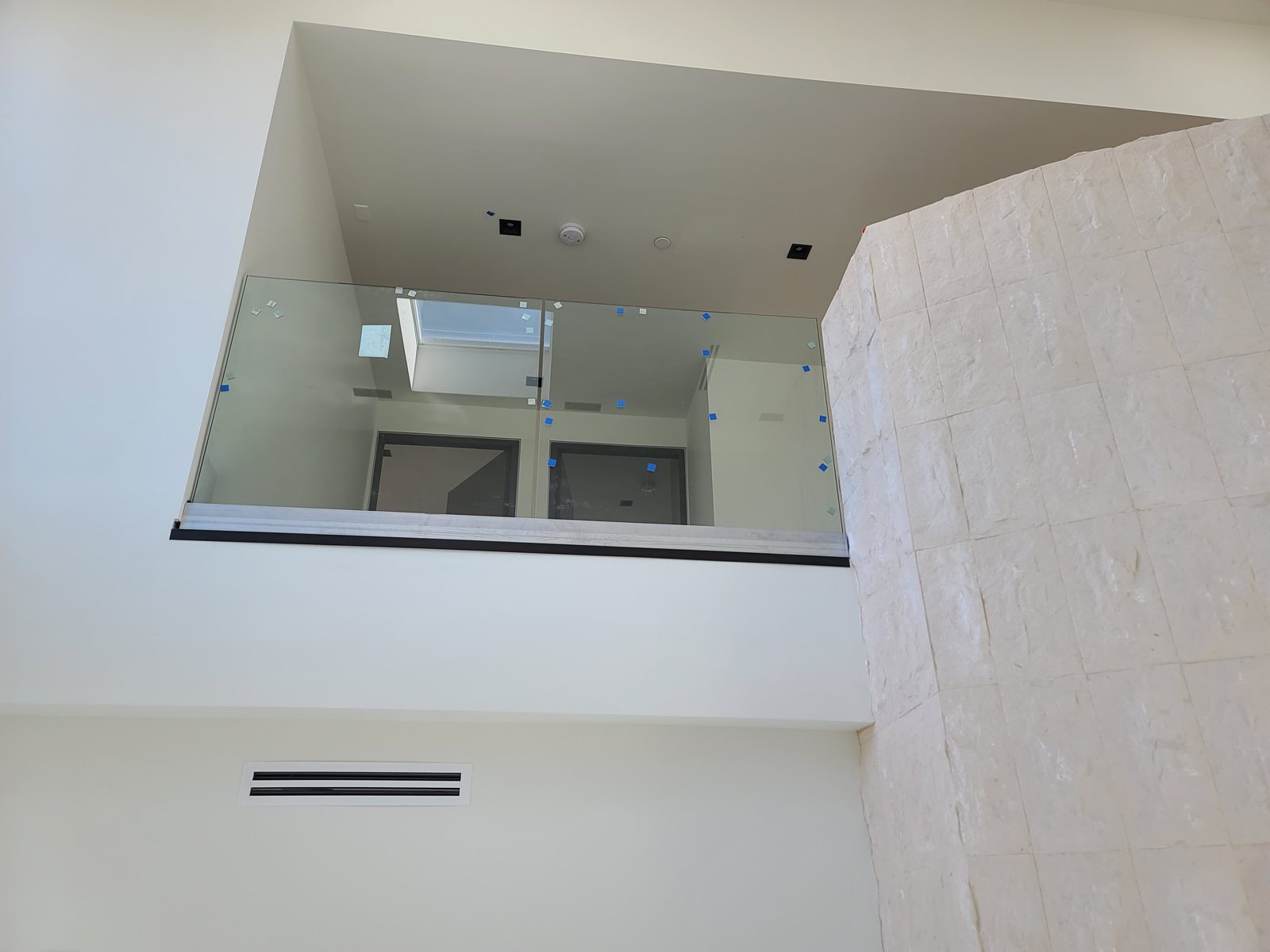 Frameless glass railing on an upper landing by Mad Touch Glass