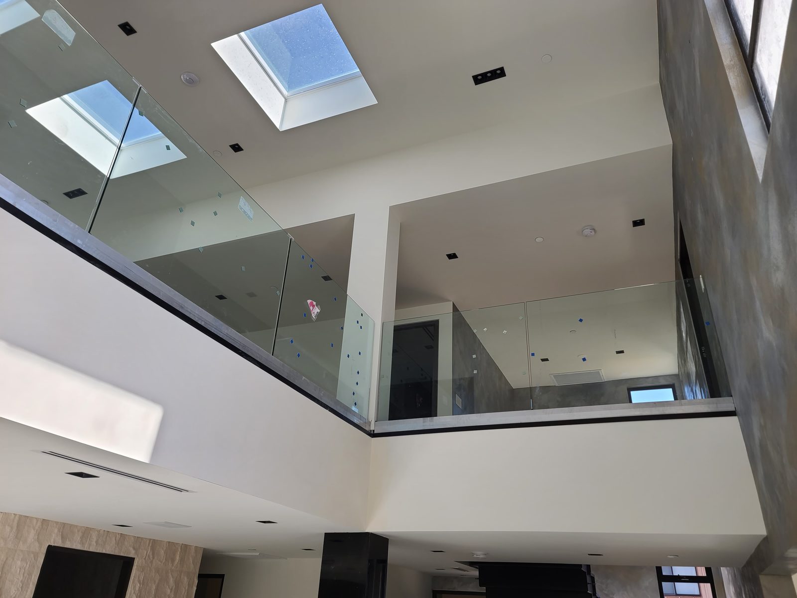 Frameless glass railing balcony under skylights by Mad Touch Glass