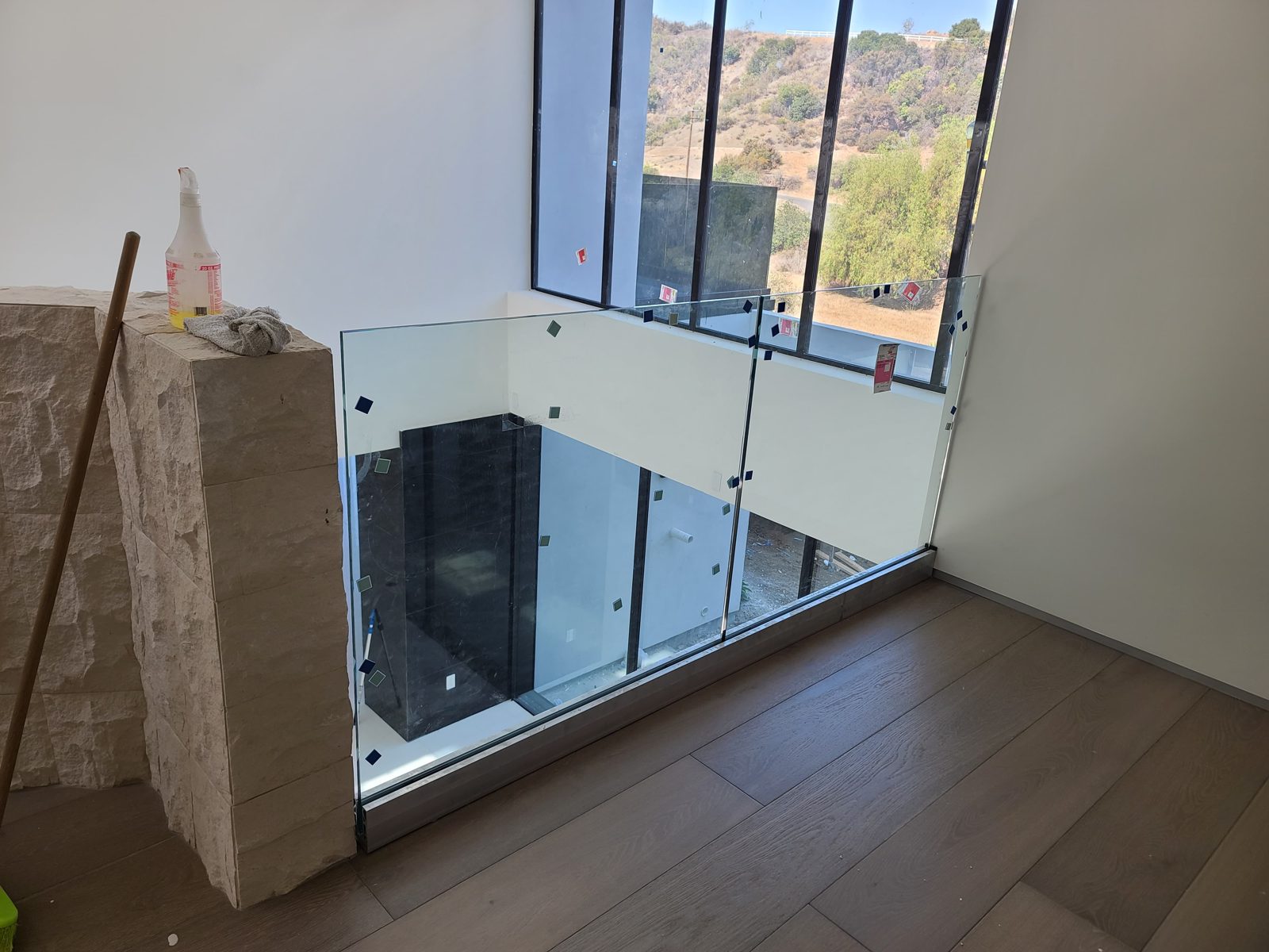 Frameless glass railing around a stair opening with a hillside view by Mad Touch Glass