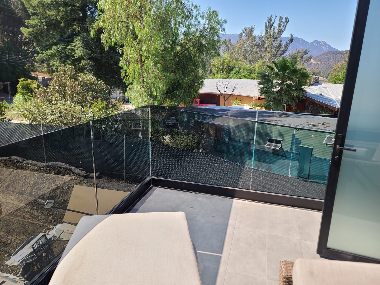Frameless glass balcony railing overlooking a pool and mountains by Mad Touch Glass
